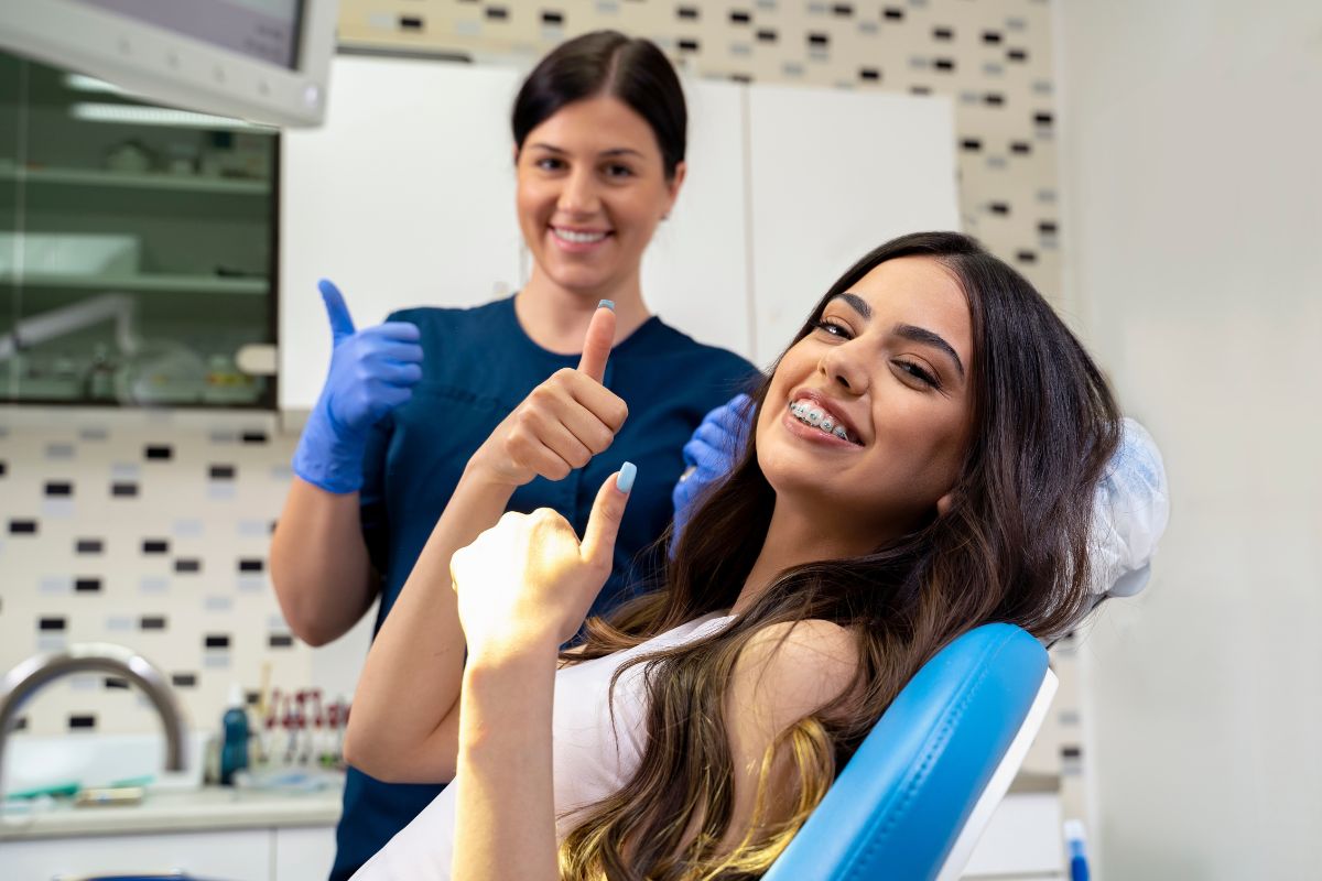 Can You Whiten Your Teeth with Braces Two dental professionals wearing blue gloves and protective gear in a modern dental office clinic.